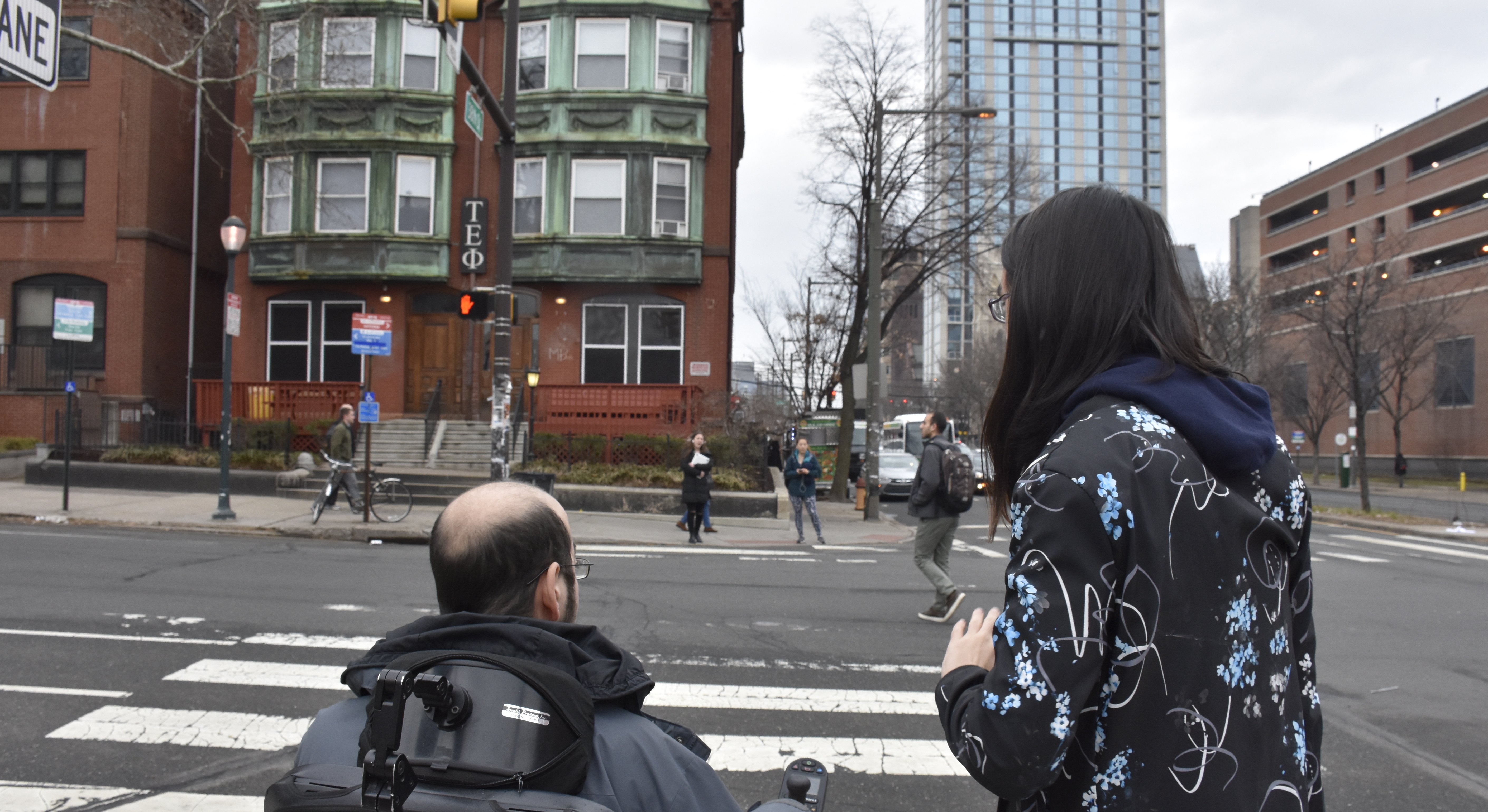 Two people about to cross a street